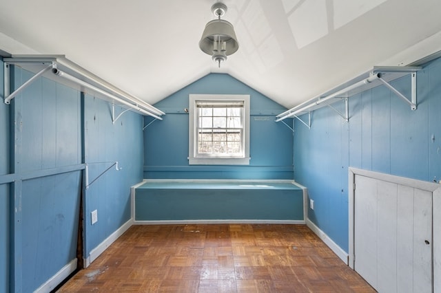 spacious closet with dark parquet flooring and lofted ceiling