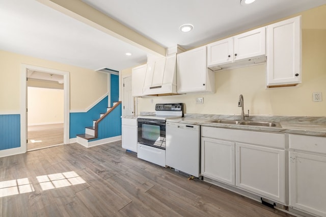 kitchen featuring white cabinetry, sink, light hardwood / wood-style floors, and white appliances