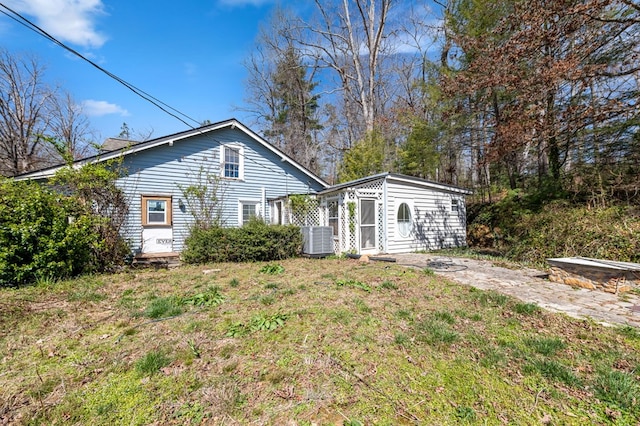 rear view of house featuring a yard and central AC