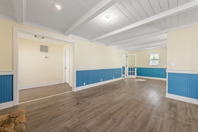 unfurnished room with beamed ceiling and wood-type flooring