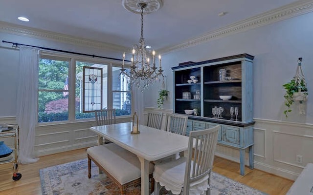 dining space featuring crown molding, a chandelier, and light wood-type flooring