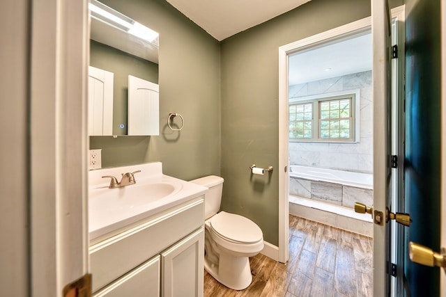 241 Boulevard St, Murphy, NC 28906 - bathroom featuring wood finished floors, toilet, tiled bath, vanity, and baseboards