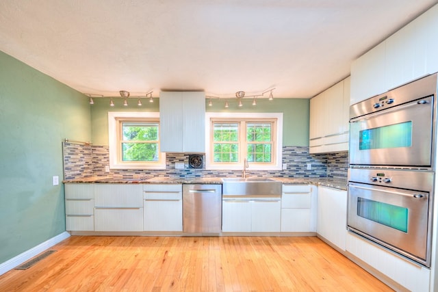 241 Boulevard St, Murphy, NC 28906 - kitchen with stainless steel appliances, a sink, decorative backsplash, and light wood finished floors