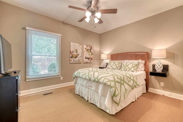 carpeted bedroom with visible vents, baseboards, and ceiling fan