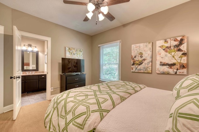 bedroom featuring baseboards, light carpet, a ceiling fan, and ensuite bathroom