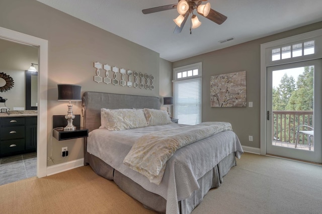 bedroom with visible vents, connected bathroom, baseboards, light colored carpet, and access to exterior