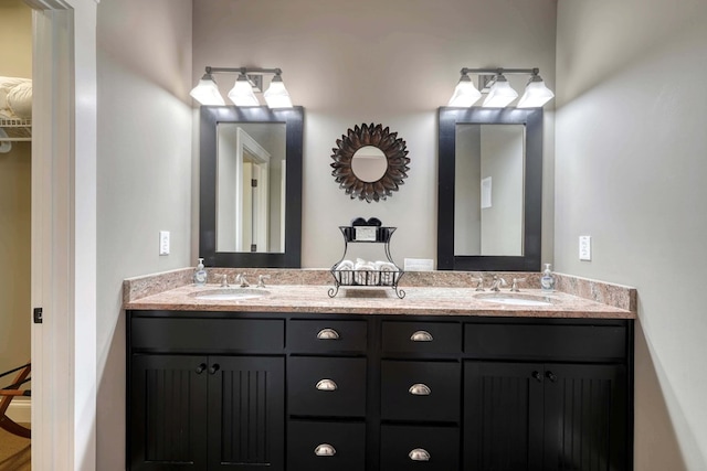 full bath with a sink, a walk in closet, and double vanity