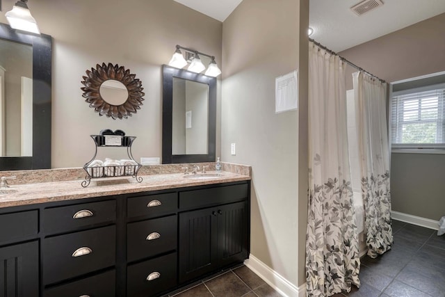 full bathroom with a sink, visible vents, double vanity, and tile patterned flooring