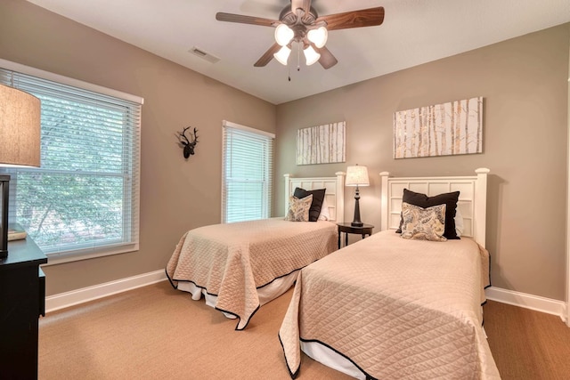 bedroom with visible vents, baseboards, and ceiling fan