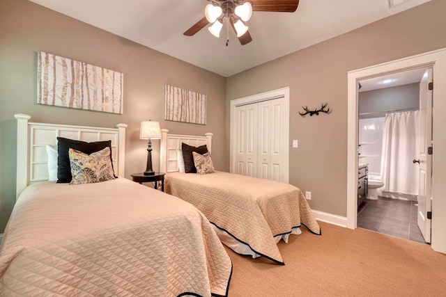 bedroom featuring a ceiling fan, baseboards, carpet floors, ensuite bath, and a closet