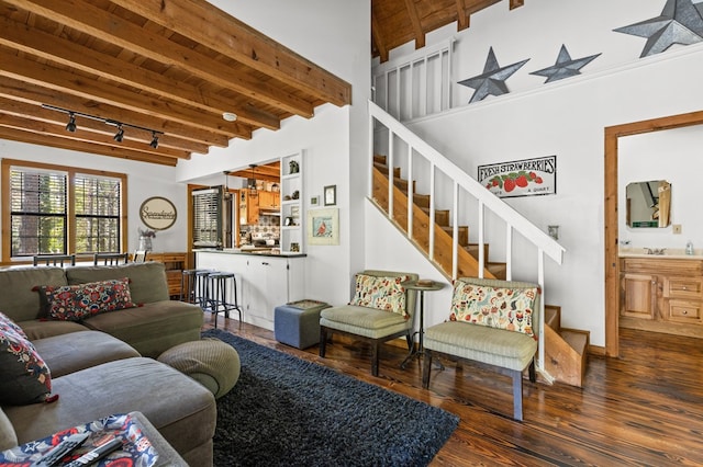 living room featuring beamed ceiling, dark wood-type flooring, sink, and rail lighting