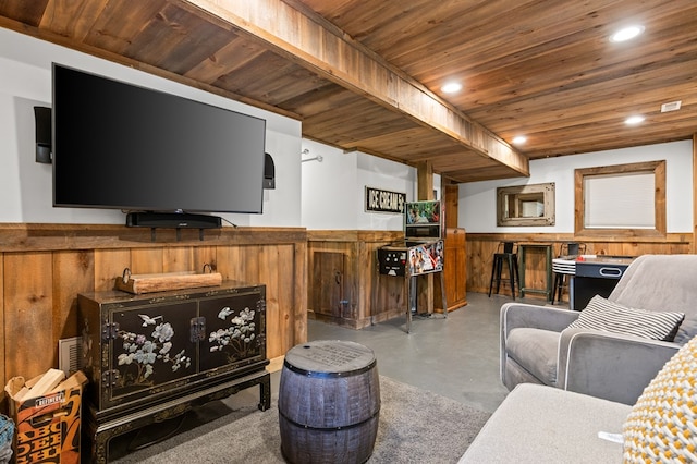 living room with concrete floors, wood walls, and wooden ceiling