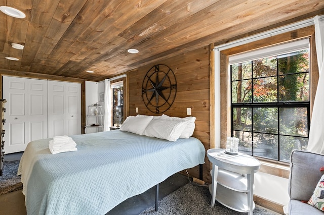 carpeted bedroom featuring wood ceiling, wood walls, and a closet