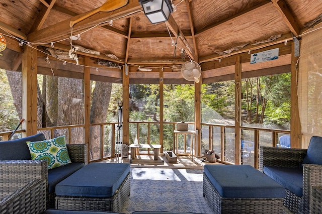 sunroom with vaulted ceiling with beams, wood ceiling, and a healthy amount of sunlight