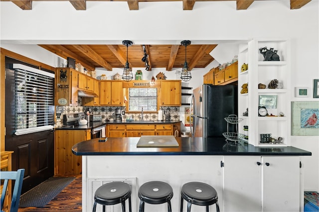 kitchen featuring beam ceiling, dark hardwood / wood-style flooring, sink, pendant lighting, and stainless steel appliances