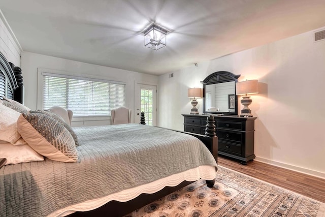 bedroom with visible vents, baseboards, and wood finished floors