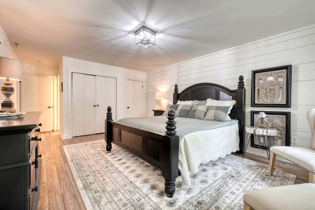 bedroom with light wood-style flooring and two closets