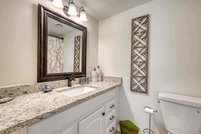 bathroom featuring vanity and toilet