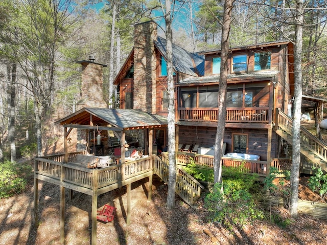 rear view of house with a wooden deck and a sunroom