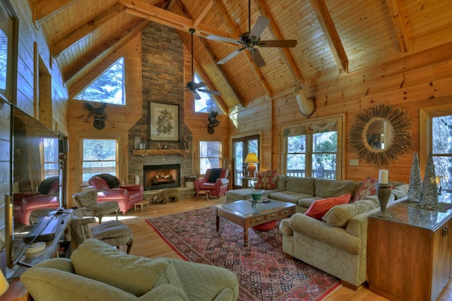 living room featuring wooden walls, high vaulted ceiling, and beamed ceiling