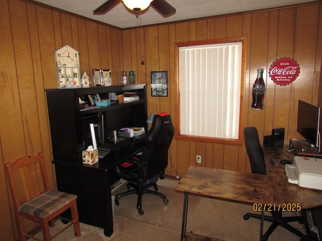 office area featuring a ceiling fan and wood walls