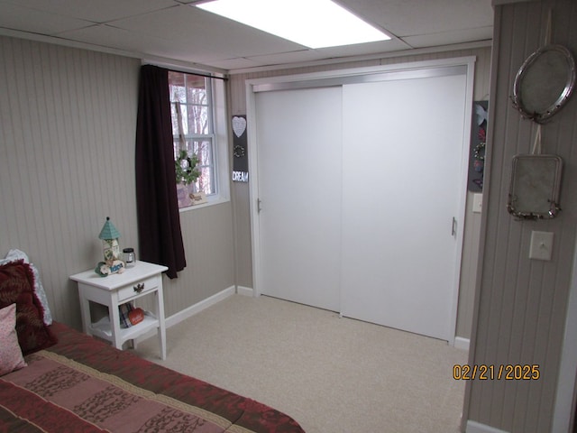 carpeted bedroom featuring a closet and a paneled ceiling