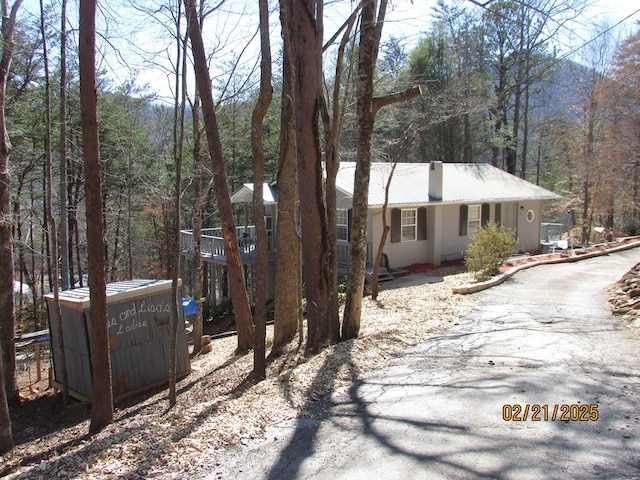 view of home's exterior featuring metal roof and a forest view