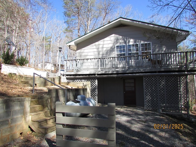 rear view of property featuring a wooden deck