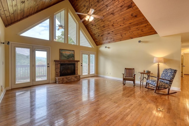 sitting room with wood ceiling, a fireplace, high vaulted ceiling, and light hardwood / wood-style flooring