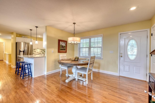 dining area with a chandelier and light wood-type flooring