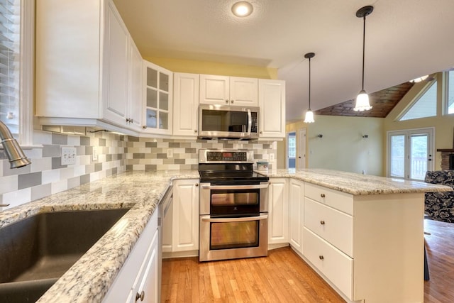 kitchen with stainless steel appliances, sink, white cabinets, and kitchen peninsula