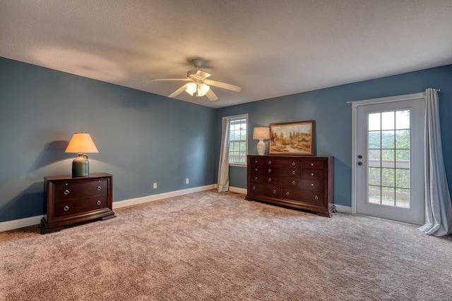 bedroom featuring ceiling fan, light colored carpet, access to exterior, and a textured ceiling