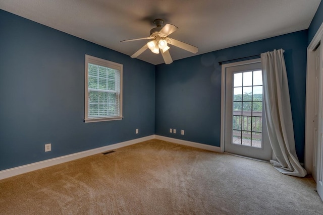 carpeted spare room with ceiling fan