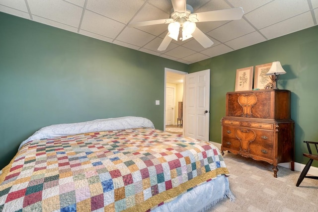 bedroom featuring light colored carpet, a drop ceiling, and ceiling fan