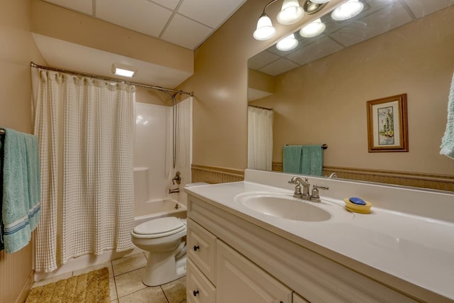 full bathroom featuring a paneled ceiling, tile patterned flooring, vanity, shower / tub combo, and toilet