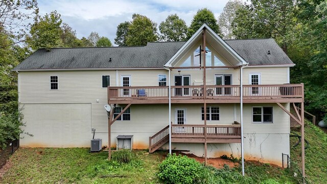 rear view of house featuring a wooden deck, a lawn, and central air condition unit