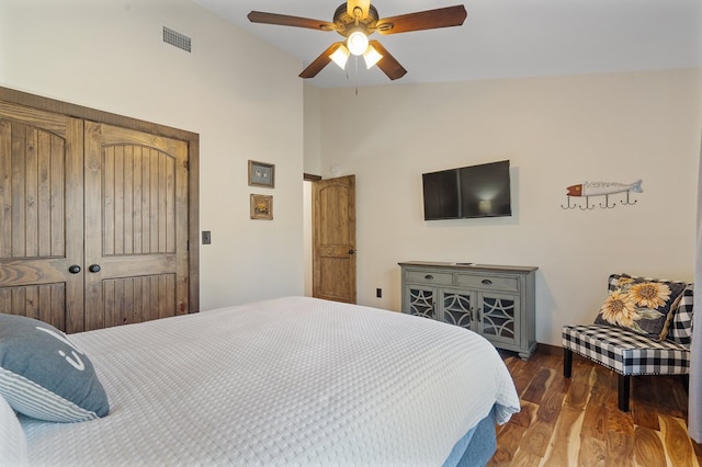 bedroom with ceiling fan, vaulted ceiling, dark hardwood / wood-style flooring, and a closet