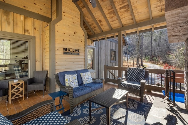 sunroom / solarium featuring vaulted ceiling with beams