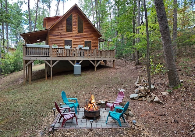 back of house with a deck, a patio, and an outdoor fire pit