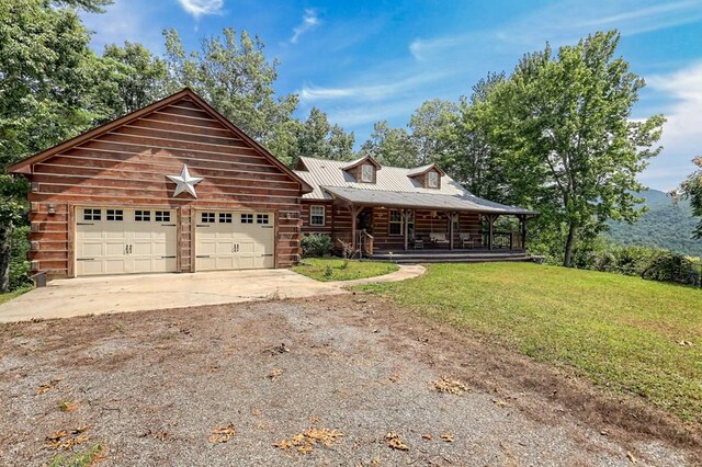 log cabin with a garage, a front yard, and covered porch