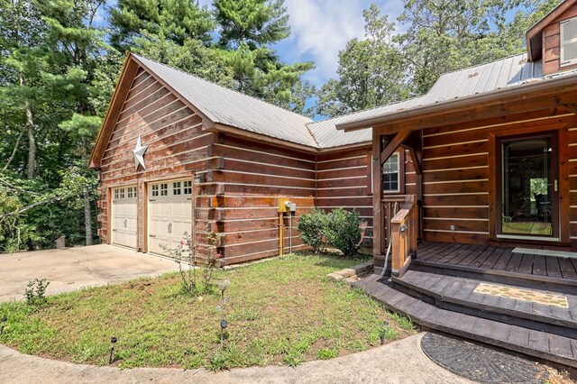 exterior space featuring a garage, a lawn, and an outbuilding