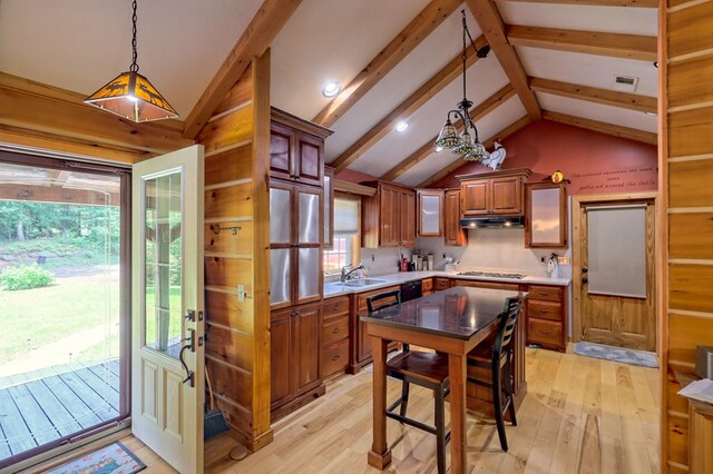 kitchen featuring vaulted ceiling with beams, light wood-type flooring, and plenty of natural light