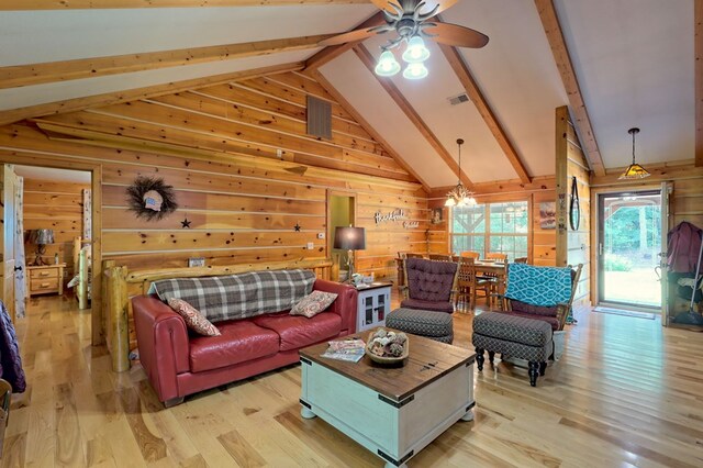 living room with vaulted ceiling with beams, wooden walls, and light wood-type flooring