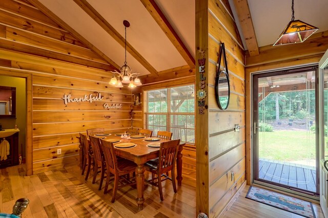 dining room with lofted ceiling with beams, hardwood / wood-style floors, and a wealth of natural light