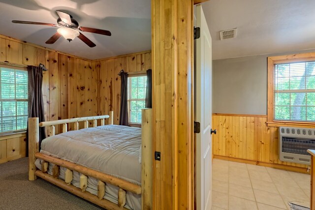 tiled bedroom with wooden walls, a wall mounted AC, and ceiling fan