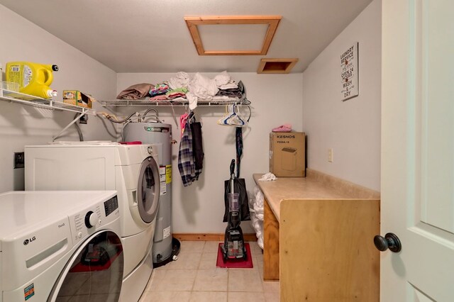 laundry room with electric water heater, washer and clothes dryer, and light tile patterned floors