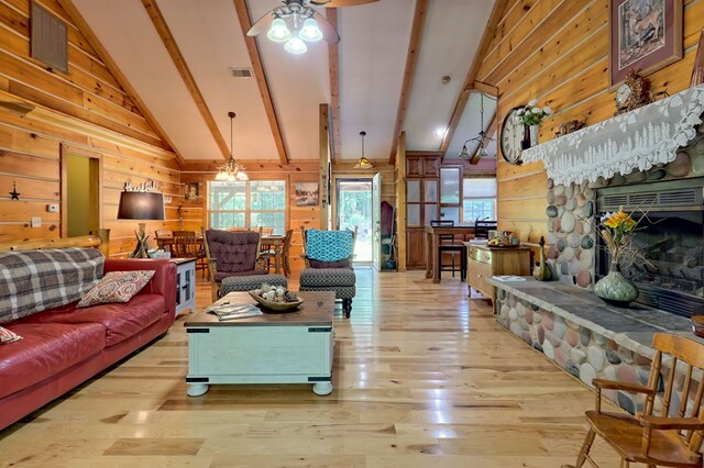 living room with wooden walls, ceiling fan with notable chandelier, vaulted ceiling with beams, and light hardwood / wood-style flooring