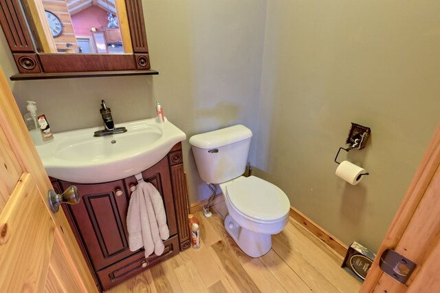 bathroom with vanity, toilet, and hardwood / wood-style floors