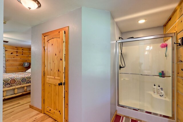 bathroom with wood-type flooring and walk in shower