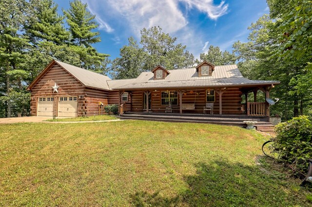 view of front of house featuring a garage, covered porch, and a front lawn